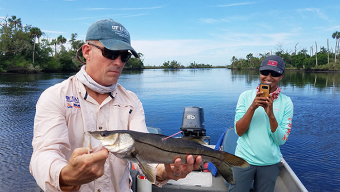 UF/IFAS Director Mike Allen and fisheries student Samara Nehemiah admire a tagged snook near Cedar Key, Florida.